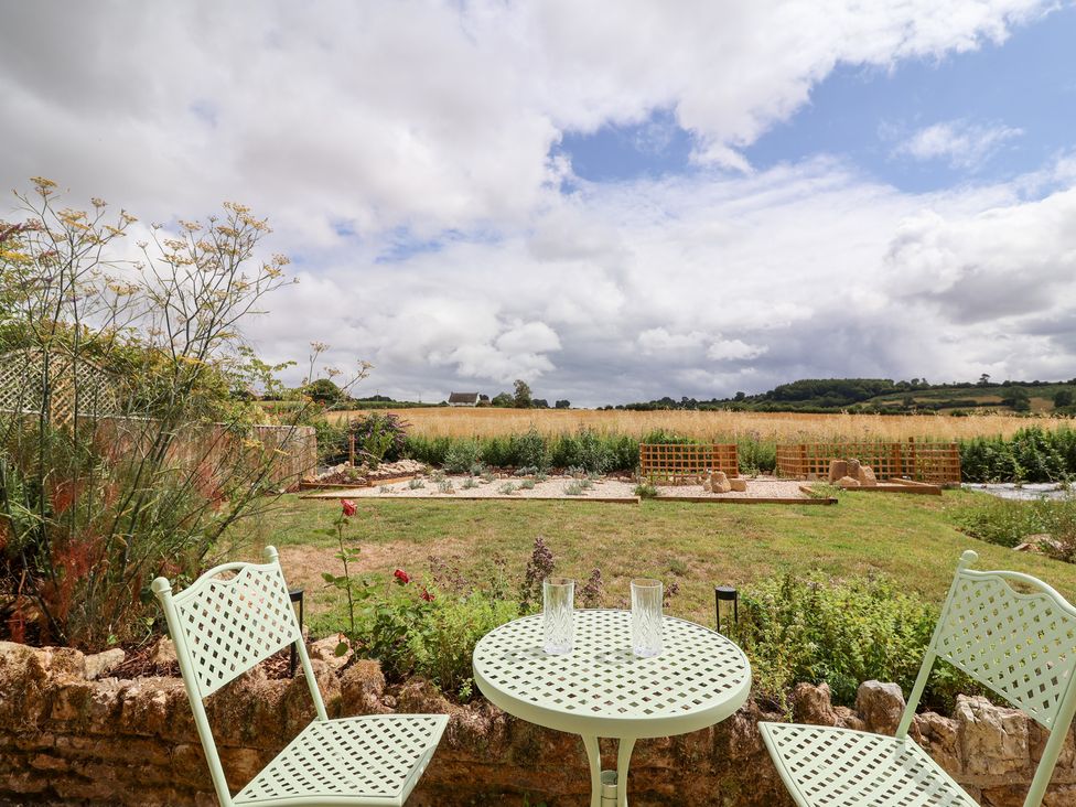 A garden with a table and chairs at Thatchers End in Sherborne