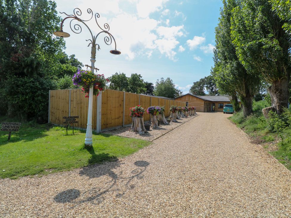 An outdoor area with a gravel path and flower pots at Robin's Nest Lodge Snettisham