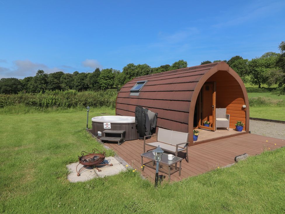 An outdoor area with a wooden building and hot tub at Ty Twt Teifi in Tregaron