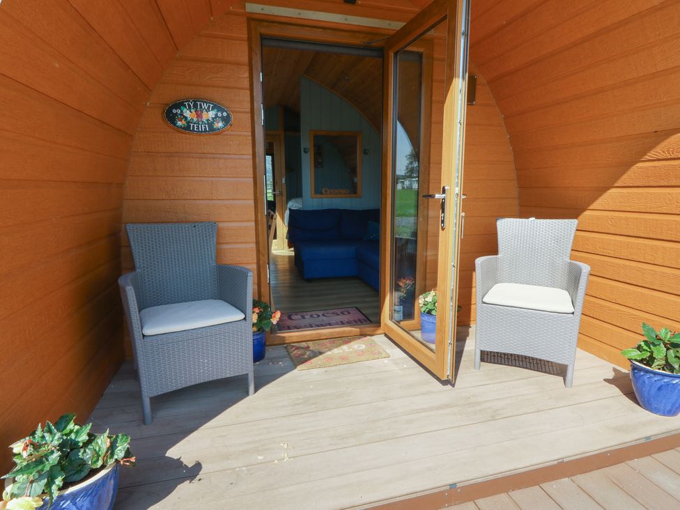 A seating area with chairs and a door at Ty Twt Teifi in Tregaron