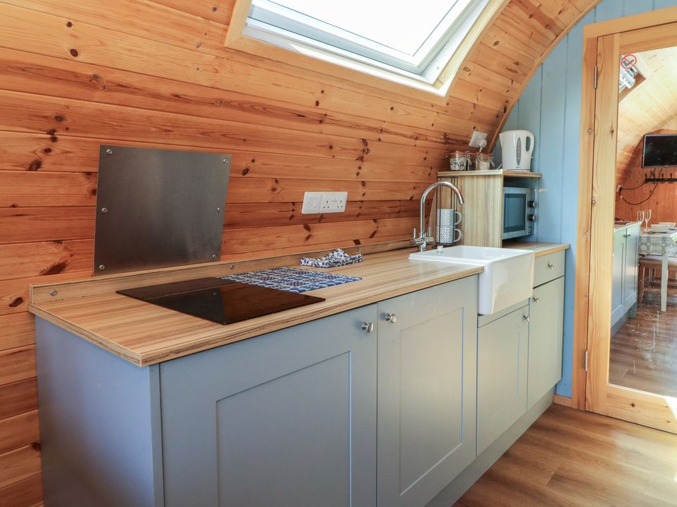 A kitchen with a sink and cooker in Ty Twt Teifi Tregaron