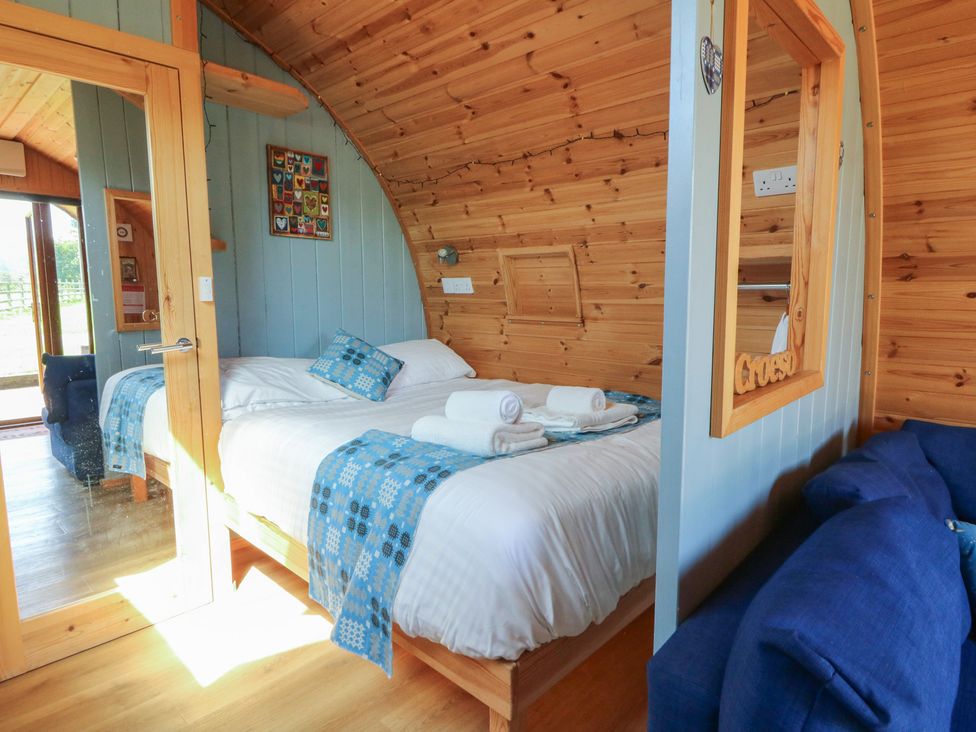 A bedroom with a bed and sofa at Ty Twt Teifi in Tregaron