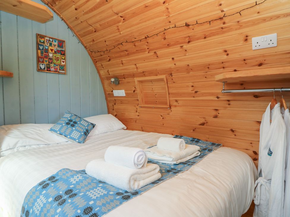 A bedroom with a bed and decorative wall art at Ty Twt Teifi in Tregaron