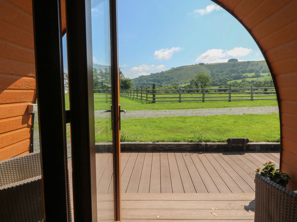 A view from a door overlooking a field and mountains at Ty Twt Teifi in Tregaron