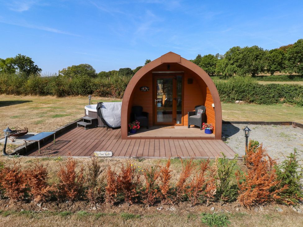 An outdoor area with a pod and hot tub at Ty Twt Teifi in Llanddewi-Brefi