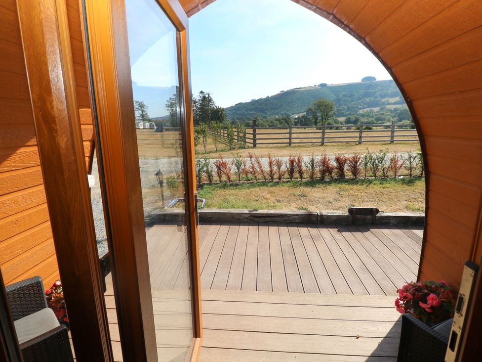 An outdoor area with a wooden deck and view of mountains at Ty Twt Teifi in Llanddewi-Brefi