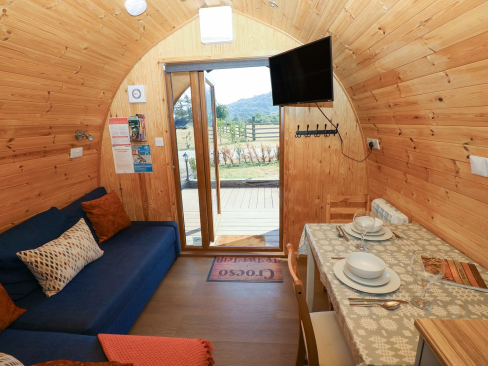 A living space with a sofa and dining area at Ty Twt Teifi in Llanddewi-Brefi