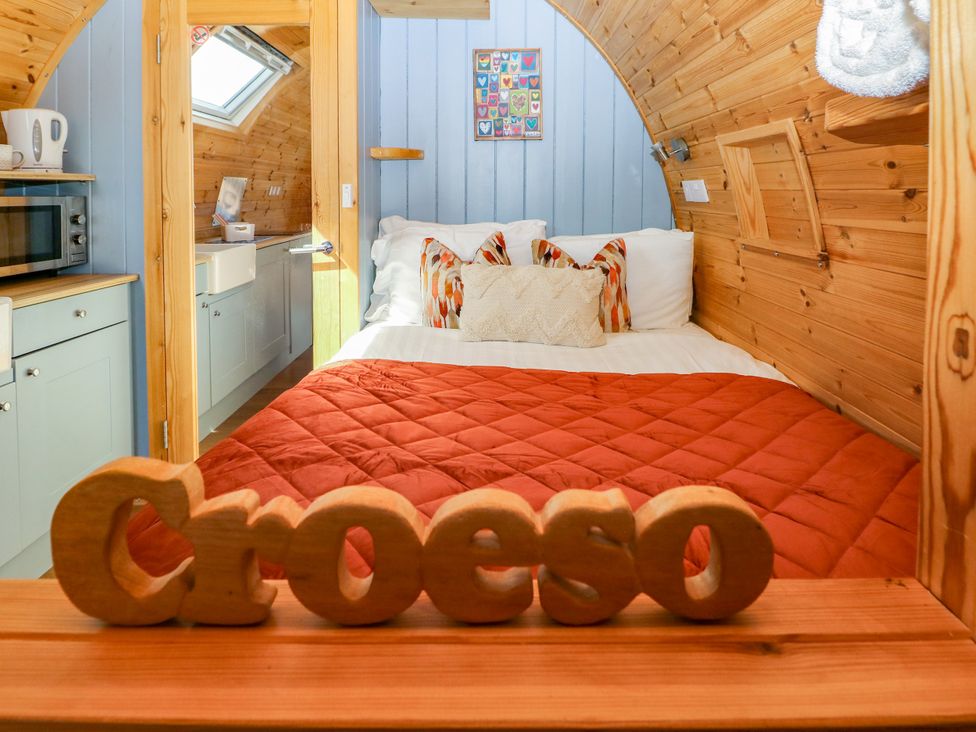 A bedroom with a bed and kitchenette area at Ty Twt Teifi in Llanddewi-Brefi