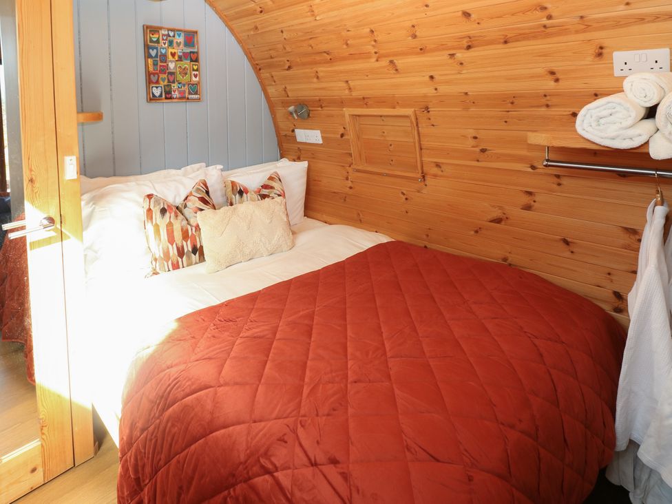 A bedroom with a bed and wall art at Ty Twt Teifi in Llanddewi-Brefi