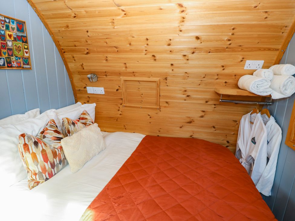 A bedroom with a bed and decorative pillows at Ty Twt Teifi in Llanddewi-Brefi