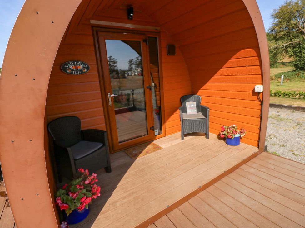 An outdoor area with chairs and flower pots at Ty Twt Teifi in Llanddewi-Brefi