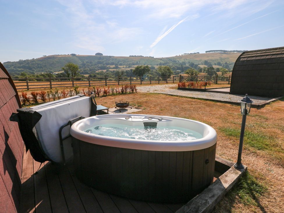 A hot tub on the deck with a landscape view at Ty Twt Teifi in Llanddewi-Brefi