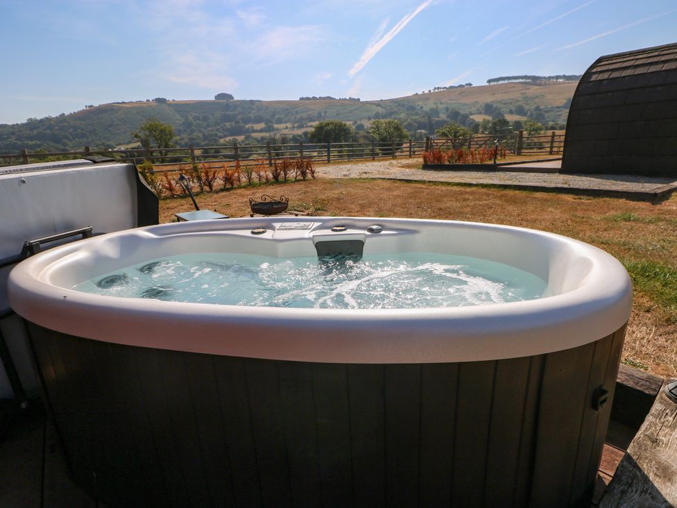 A hot tub with water in an outdoor area at Ty Twt Teifi in Llanddewi-Brefi