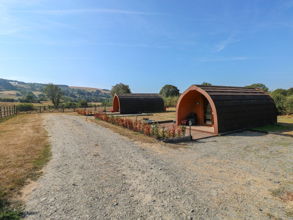 Two camping pods with a gravel path at Ty Twt Teifi in Llanddewi-Brefi