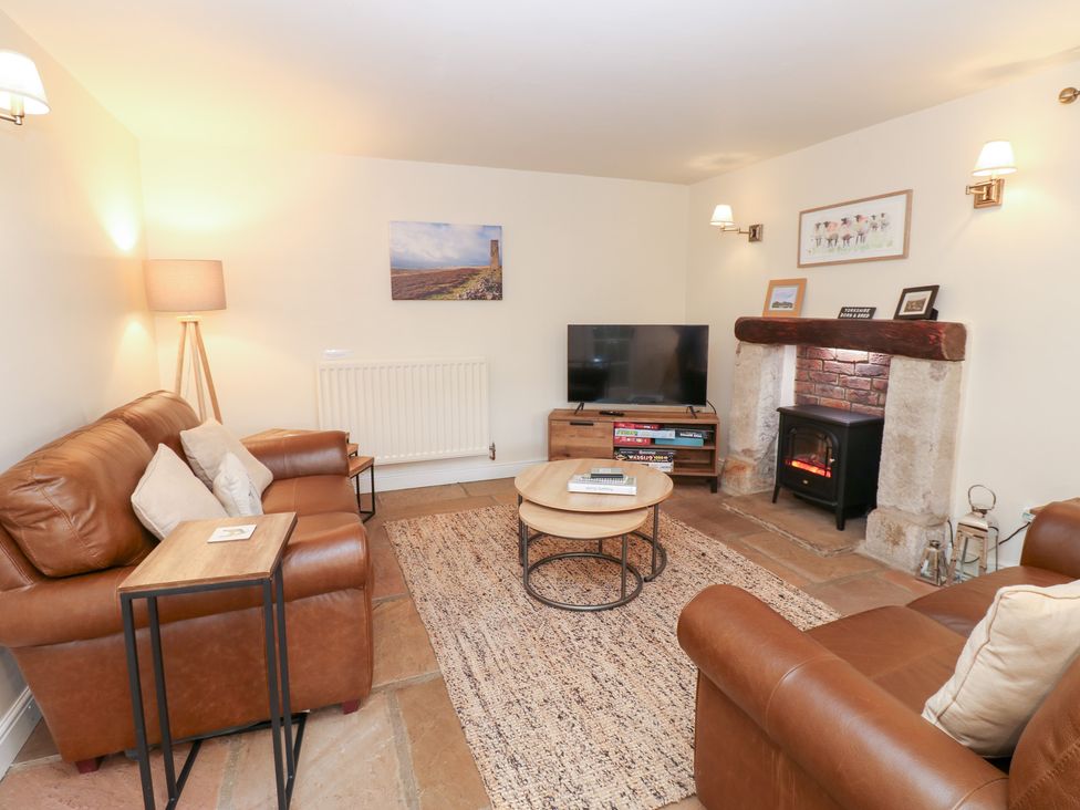 A living room with a sofa and television at Nick Jone in Richmond