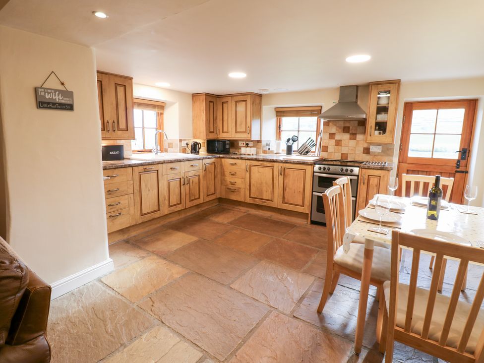 A kitchen with wooden cabinets and a dining table at Nick Jone in Richmond