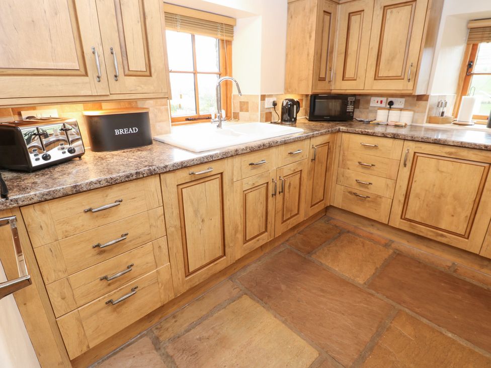 A kitchen with wooden cabinets and appliances at Nick Jone in Richmond