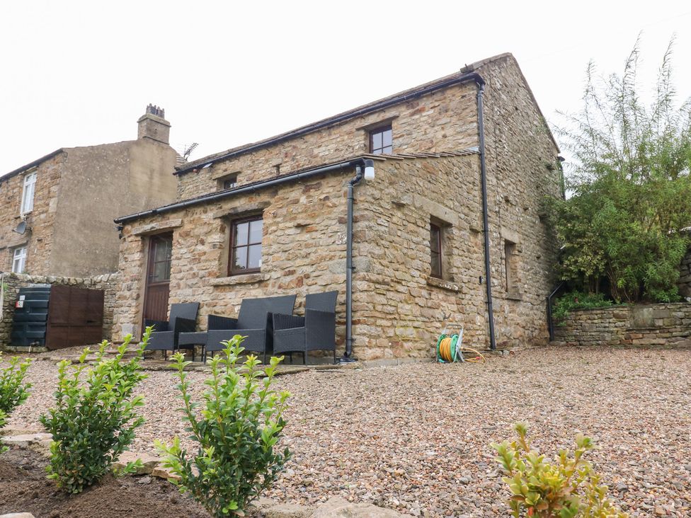 A stone building with outdoor seating in a garden at Nick Jone in Richmond