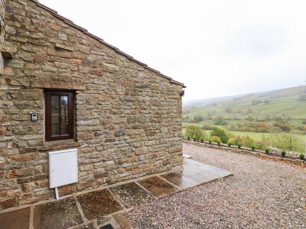 An outdoor view of a stone building with a window and gravel ground at Nick Jone in Richmond