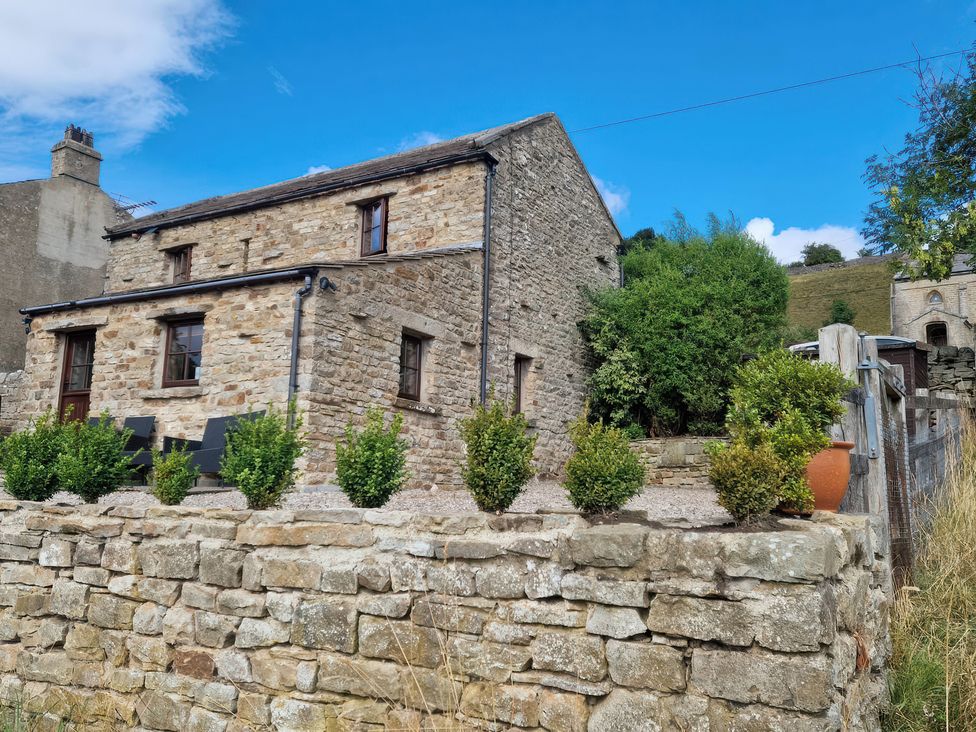 A stone house with bushes in an outdoor area at Nick Jone in Reeth