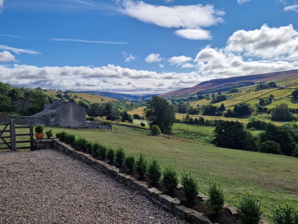 A view of the countryside with a house and gate at Nick Jone in Reeth