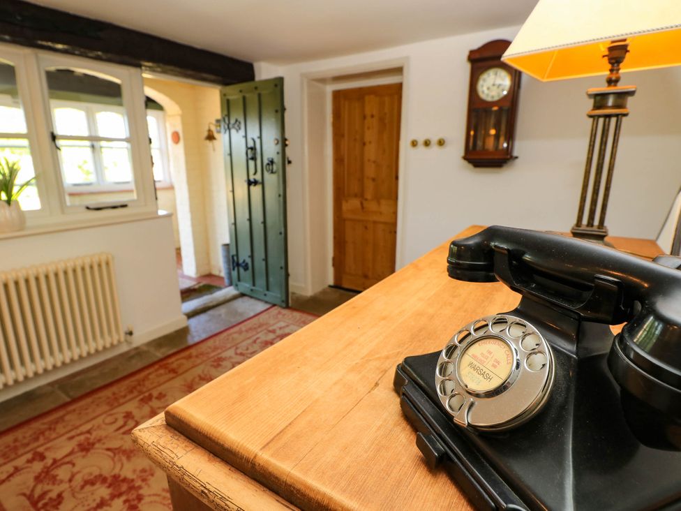An entrance hall with a black telephone on a table at Beam Cottage in Warsash