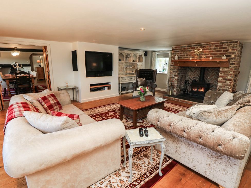 A living room with a sofa coffee table and fireplace at Beam Cottage in Warsash