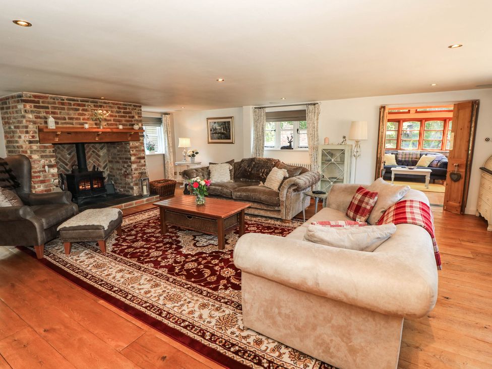 A living room with a fireplace and seating at Beam Cottage in Warsash