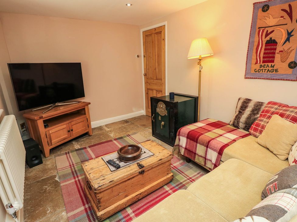 A snug with a television and coffee table at Beam Cottage in Warsash