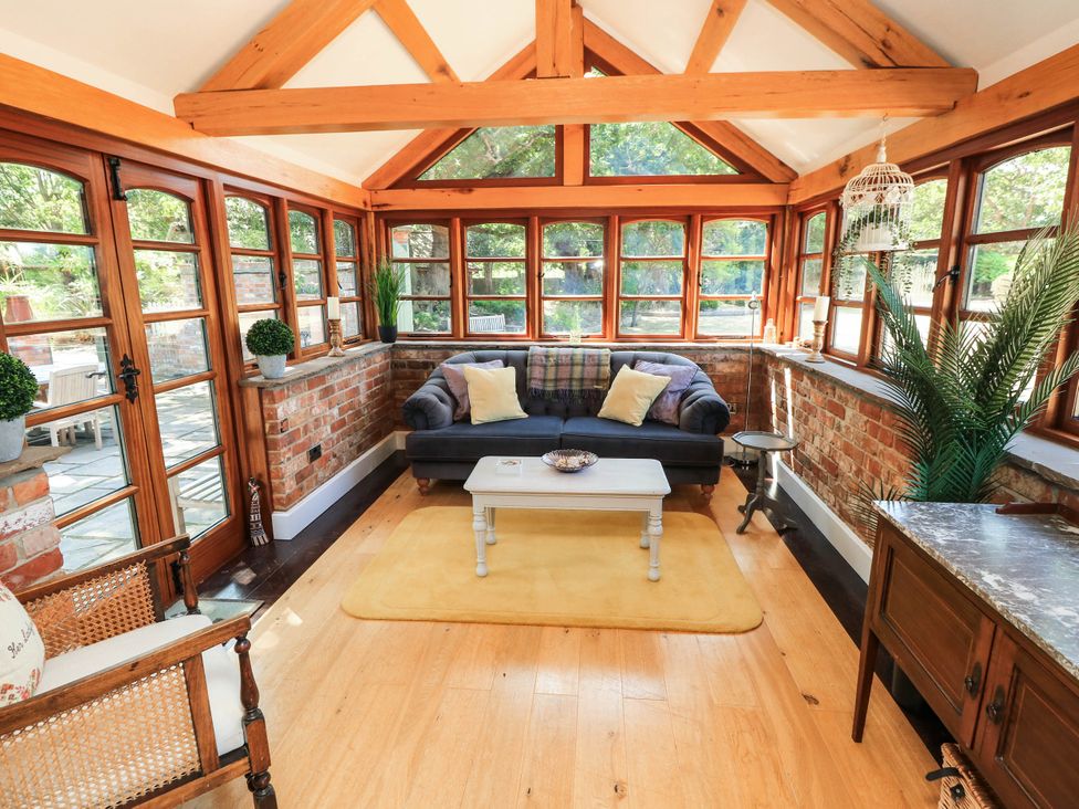 A conservatory with a sofa and a coffee table at Beam Cottage in Warsash