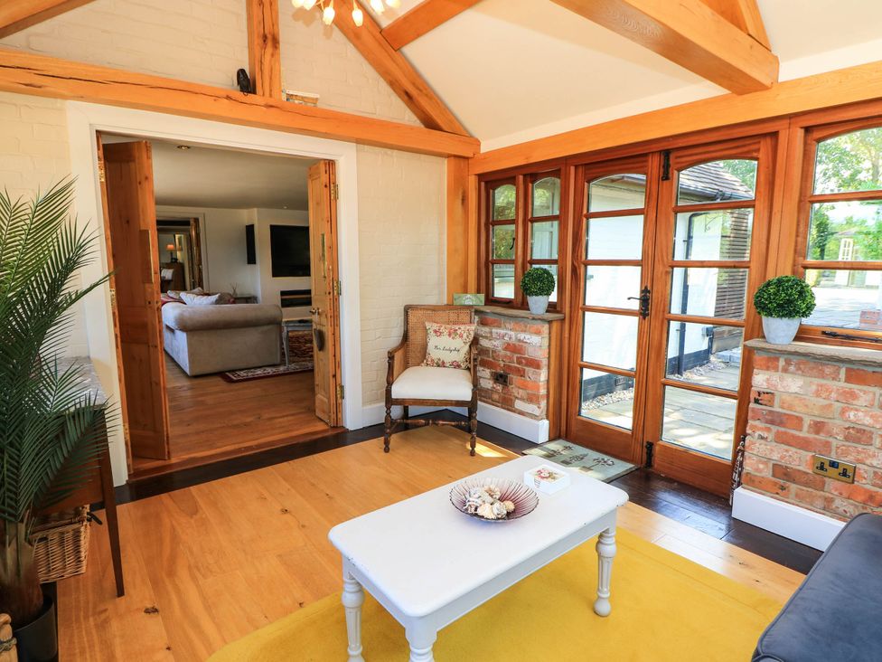 A conservatory with a coffee table and sofa at Beam Cottage in Warsash