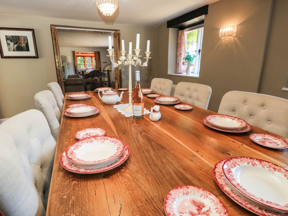 A dining room with a wooden table set for a meal at Beam Cottage in Warsash