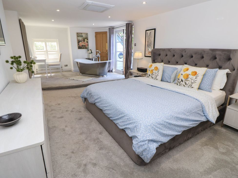 A bedroom with a bed and a bathtub at Beam Cottage in Warsash