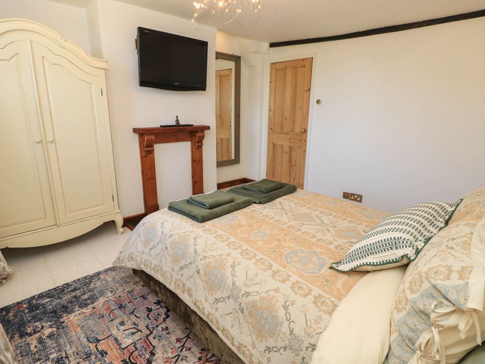 A bedroom with a bed and armoire at Beam Cottage in Warsash