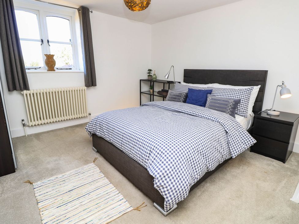 A bedroom with a bed and shelving unit at Beam Cottage in Warsash
