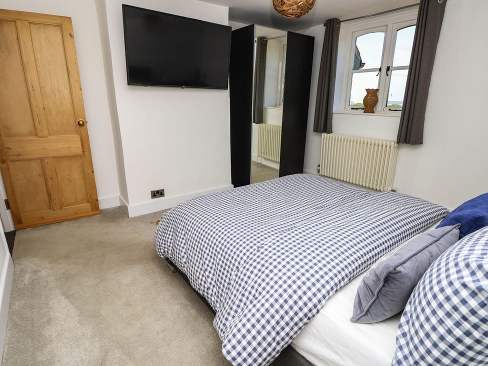 A bedroom with a bed and television at Beam Cottage in Warsash