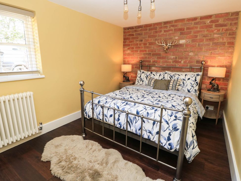 A bedroom with a bed and nightstands at Beam Cottage in Warsash