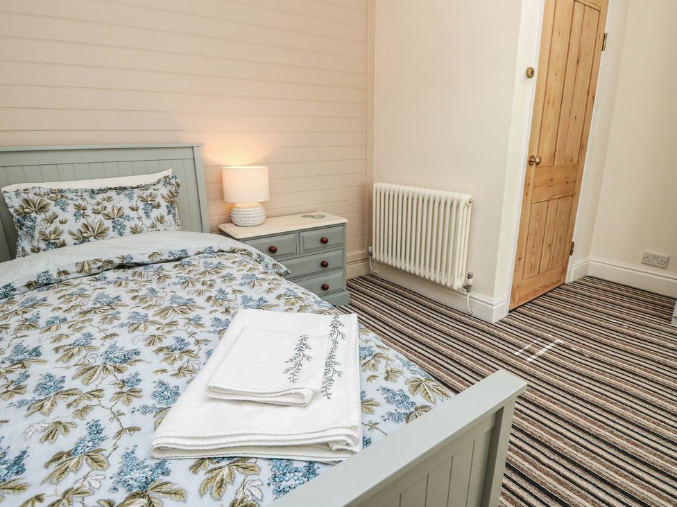 A bedroom with a bed and a nightstand at Beam Cottage in Warsash