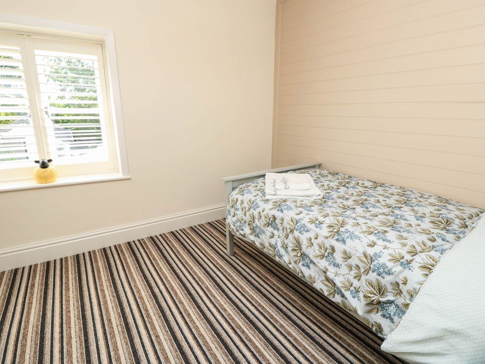 A bedroom with a bed and window at Beam Cottage in Warsash