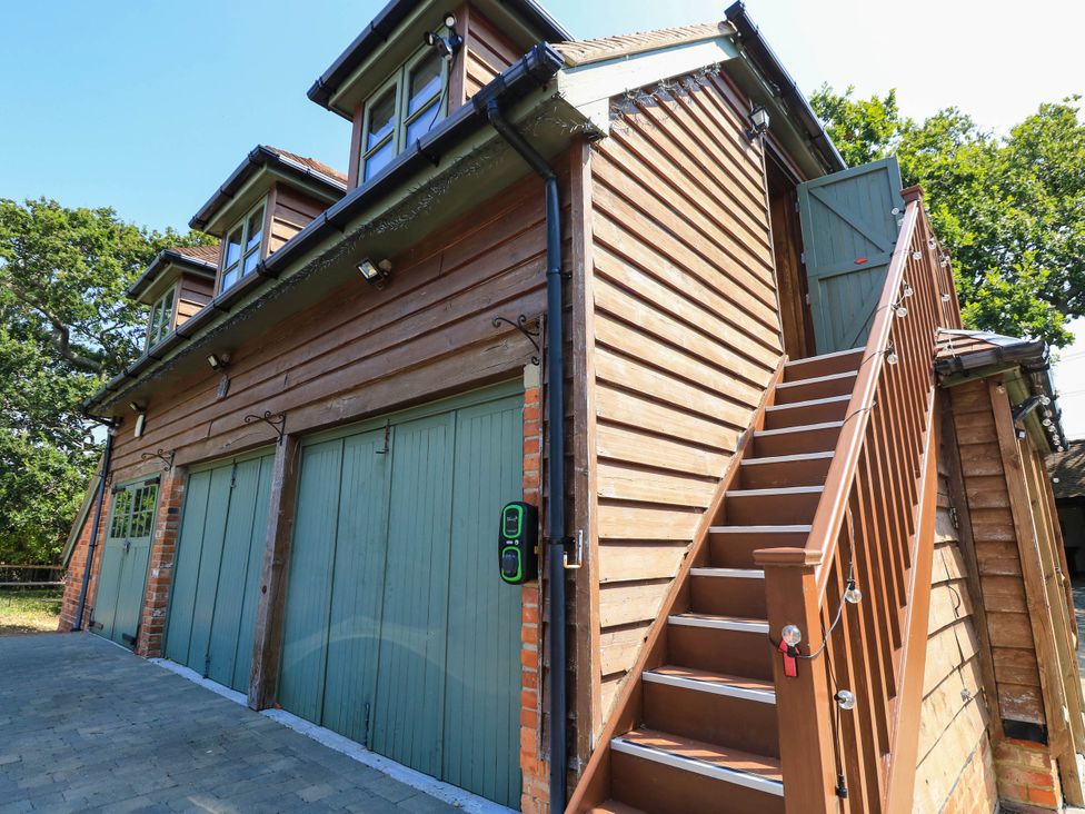 A garage with stairs leading to an upper level at Beam Cottage in Warsash
