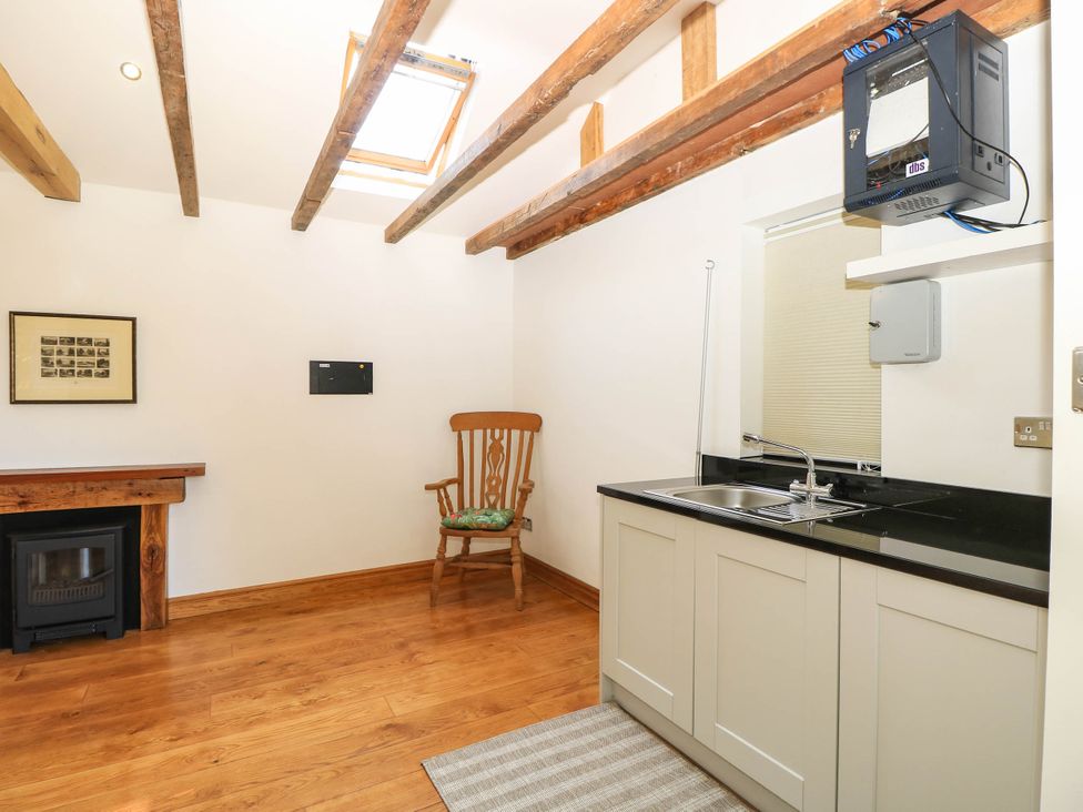 A kitchen with a sink and wooden beams at Beam Cottage in Warsash