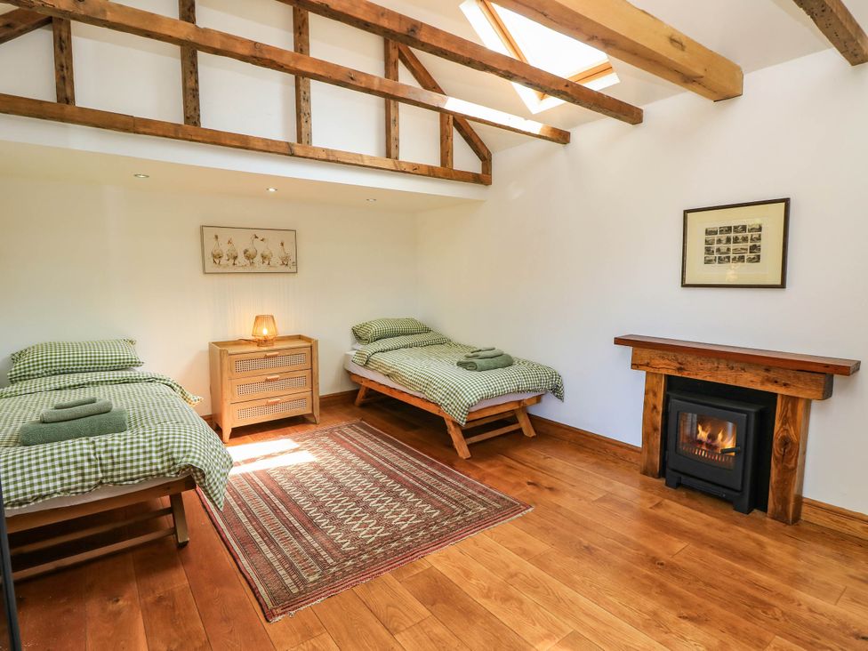 A bedroom with two beds and a fireplace at Beam Cottage in Warsash