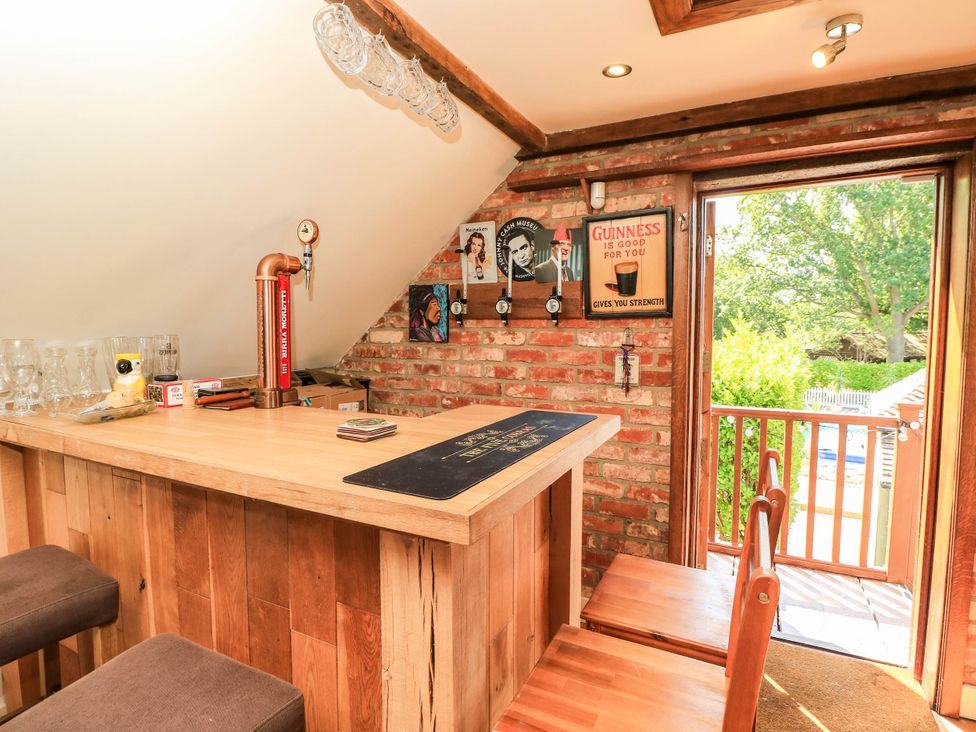A home bar with wooden counter and beer tap at Beam Cottage in Warsash