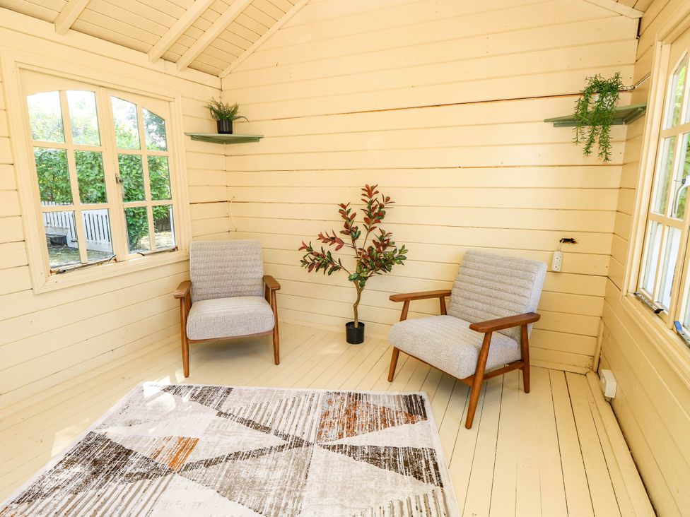 A snug with two chairs and a potted plant at Beam Cottage in Warsash