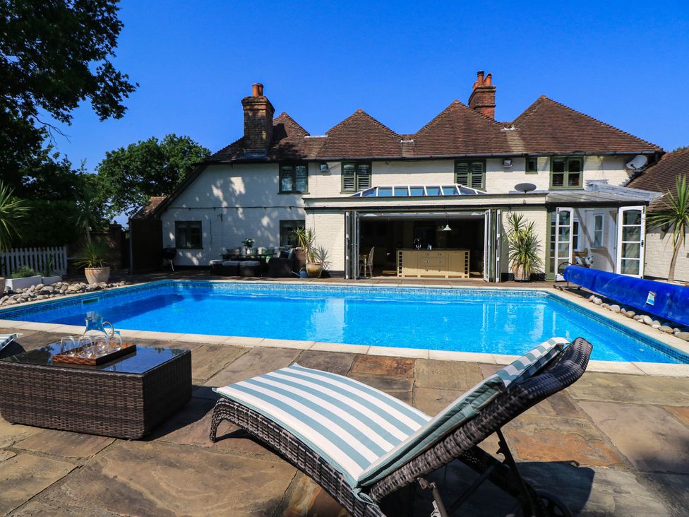 An outdoor area with a swimming pool and a deck chair at Beam Cottage in Warsash
