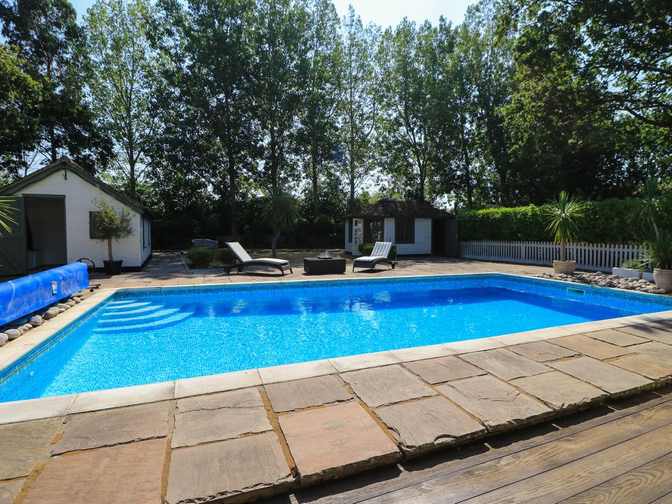 An outdoor area with a swimming pool and sun loungers at Beam Cottage in Warsash