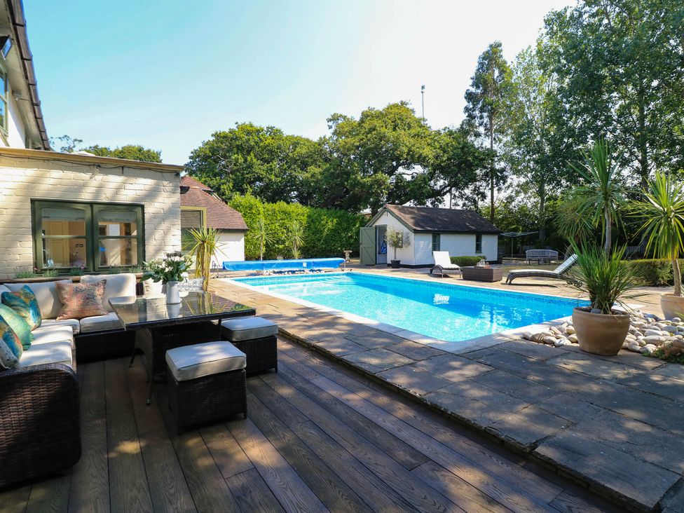 An outdoor area with a swimming pool and seating at Beam Cottage in Warsash