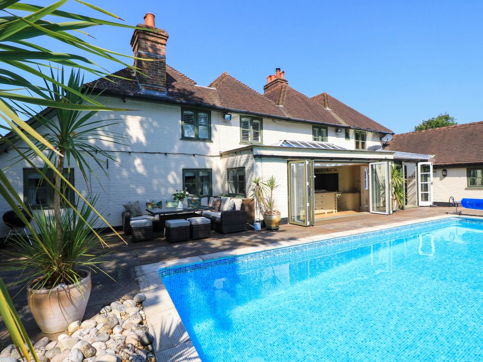 An outdoor area with a swimming pool and seating at Beam Cottage in Warsash