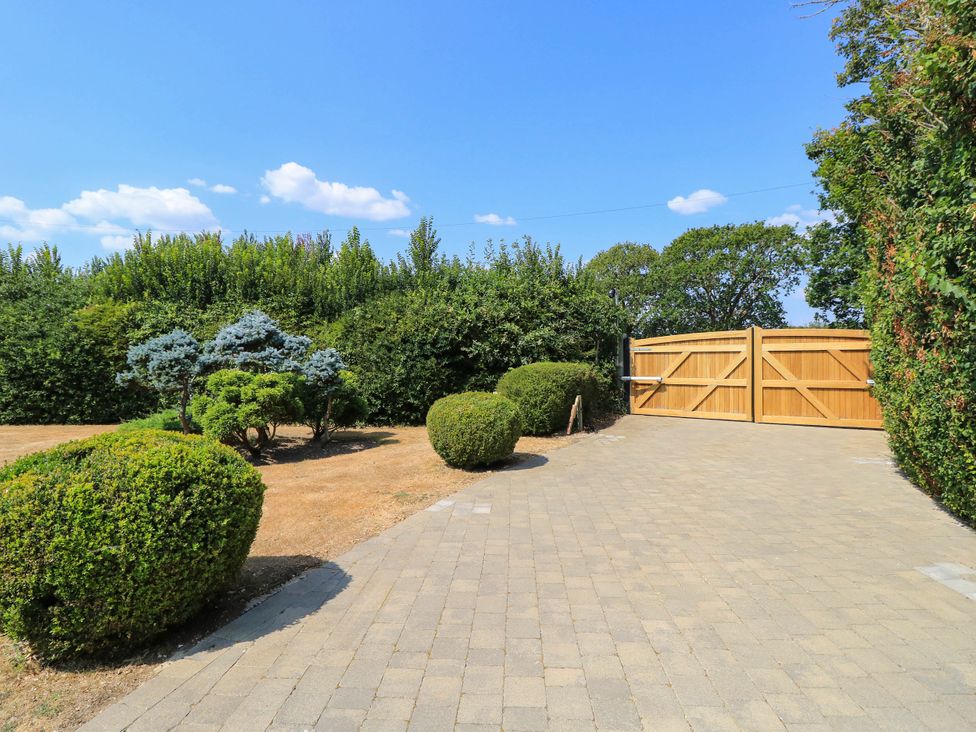 An outdoor view with a wooden gate and landscaped garden at Beam Cottage in Warsash