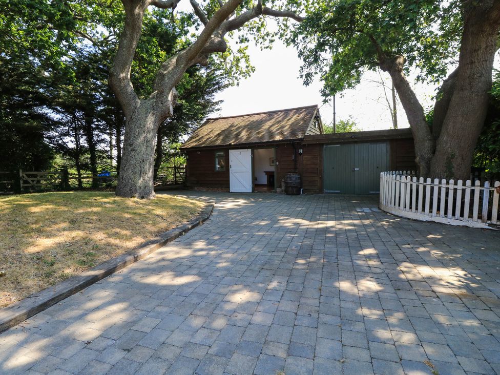 A garage with a paved driveway at Beam Cottage in Warsash